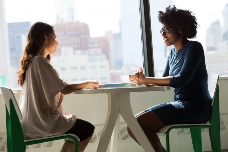 Two people sitting at a table having a conversation