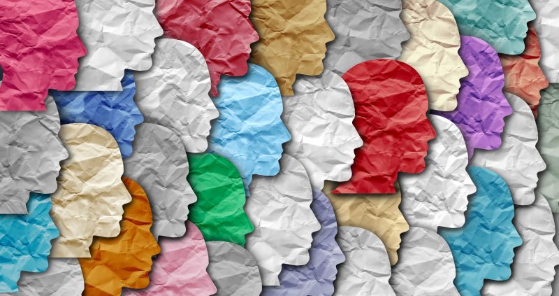 Colourful heads profiles made from material in a row facing to the right