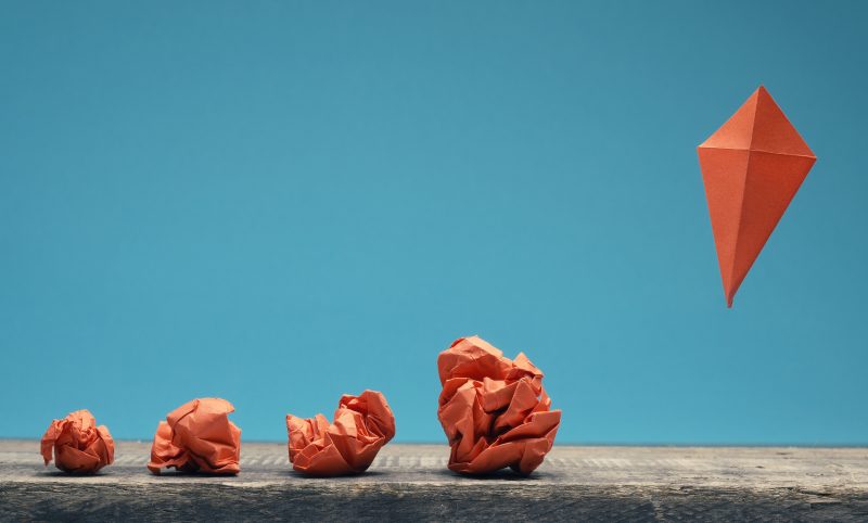 Orange kites flying away on a blue background