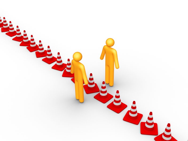 Traffic cones in a line with a yellow figure on either side