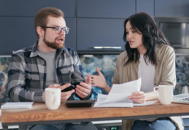 Two people having a conversation whilst drinking coffee and looking at paperwork