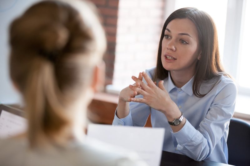 Two professional office workers talking in an office.