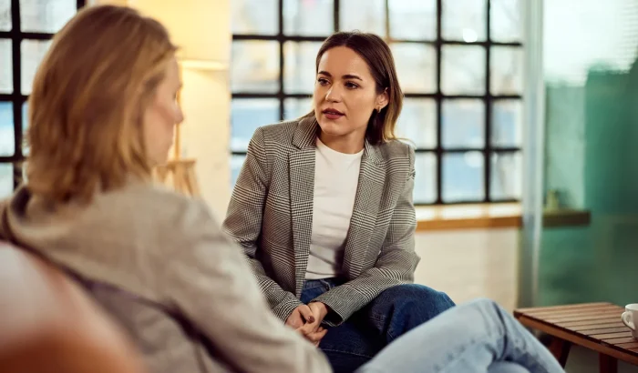 Manager listening carefully as a colleague raises a concern at work